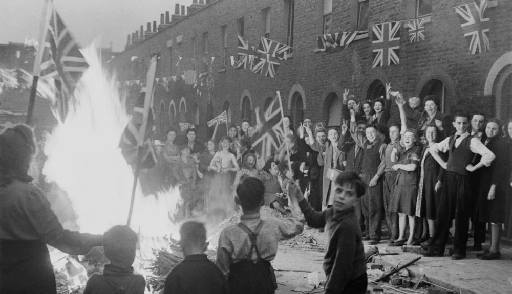 Black and white photograph of Residents of a bombed London street celebrating VE Day, caught on film by Leonard McCombe. (Courtsey McCombe family)