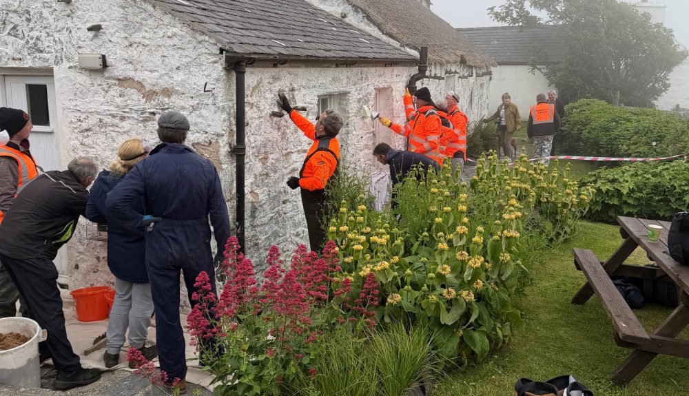 Community Rangers explore traditional building conservation methods at a limewashing workshop in Cregneash.